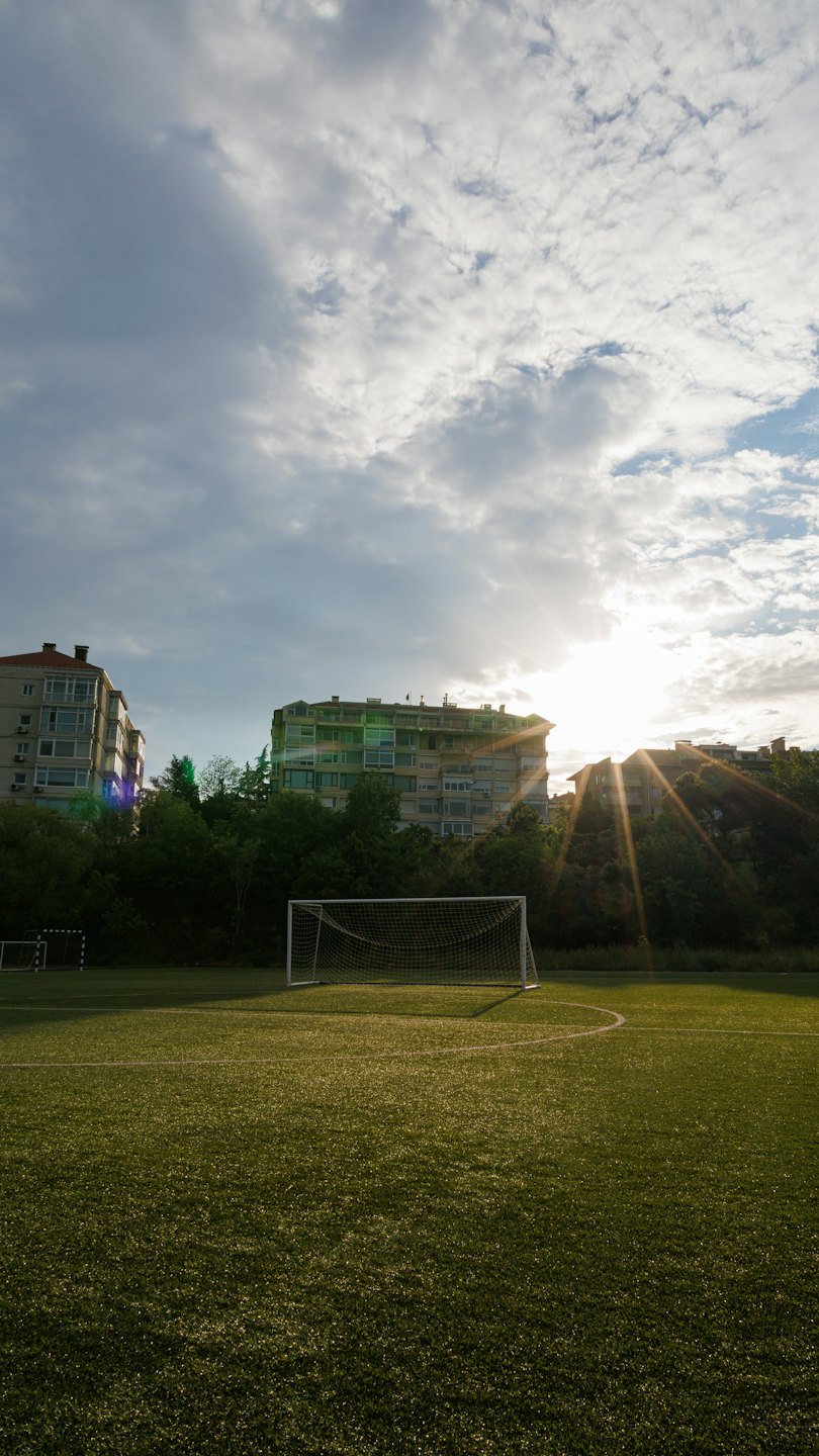A white goal sits on an outdoor artificial turf football pitch.