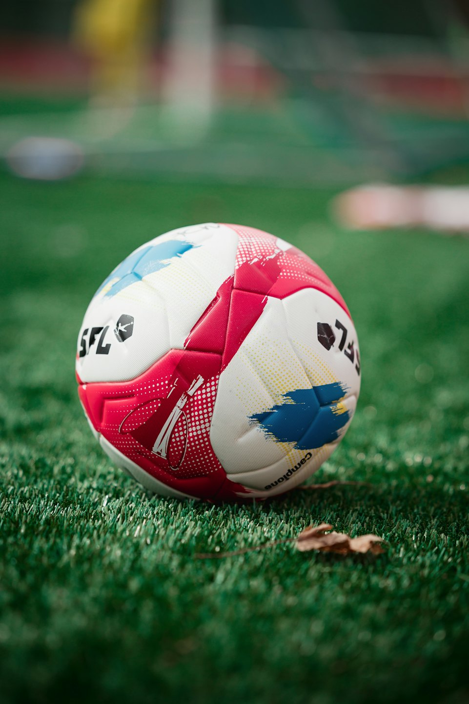 A soccer ball rests on artificial green turf.